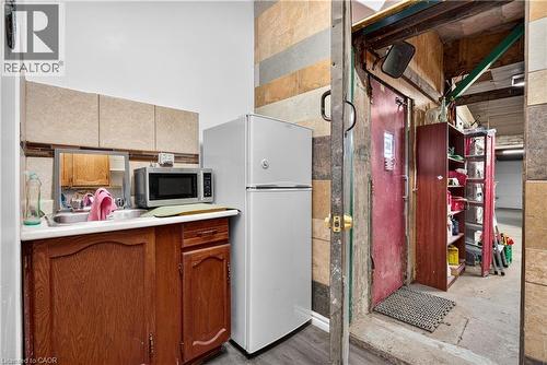 Wood-finish base cabinetry with a white countertop and stainless steel sink - 689 Barton Street E, Hamilton, ON 