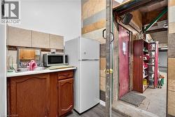 Wood-finish base cabinetry with a white countertop and stainless steel sink - 
