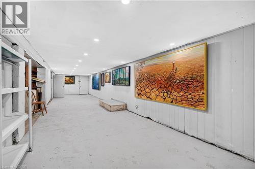 Recessed ceiling lighting illuminates a spacious room featuring paneled walls and a concrete floor - 689 Barton Street E, Hamilton, ON 
