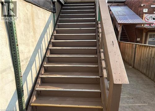 Exterior staircase with wood-finish treads and risers, featuring a coordinating wood-finish handrail - 689 Barton Street E, Hamilton, ON 