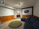 Stone fireplace with hearth, wood-paneled walls, track lighting, and carpeted flooring - 511 Havelock Drive, Waterloo, ON 