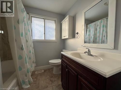 Bathroom featuring a window with privacy glass, a built-in vanity with under-sink storage, an integrated sink, and tiled flooring - 511 Havelock Drive, Waterloo, ON 
