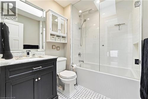 Dark vanity with marble top, mosaic tiling, glass tub surround and white ceramic tiling. Toto toilet - 58 Uplands Avenue, Hamilton, ON 