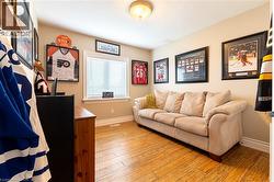 Wood-finish flooring, neutral wall color, window with blinds, and white trim throughout - 