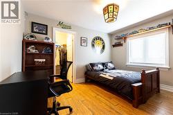 Wood-finish flooring, built-in shelving, white trim, recessed lighting, and a walk-in closet - 