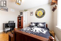 Wood-finish flooring, white paneled door, and a built-in ceiling light fixture - 