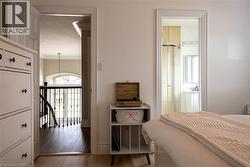 Hardwood flooring, decorative wrought iron balusters, arched window, built-in shower enclosure, and vanity with undermount sink - 