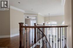 Hardwood flooring, crown molding, recessed lighting, wrought iron balusters, and arched windows - 