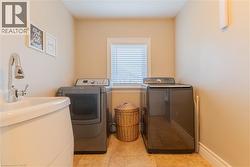 Laundry area with a built-in utility sink featuring a chrome pull-down faucet, tile flooring, and a window with blinds - 