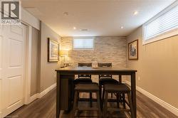 Recessed lighting illuminates the wood-finish flooring and stone accent wall - 