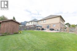 Expansive lawn area with a wood-sided storage shed and a full privacy fence - 