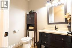 Dark wood-finish vanity with drawer storage, light-toned countertop, and undermount sink - 