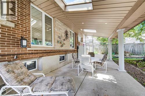 Brick exterior with stone accents, covered concrete patio, skylights, recessed lighting, and a columned support - 192 Warren Road, Kitchener, ON 
