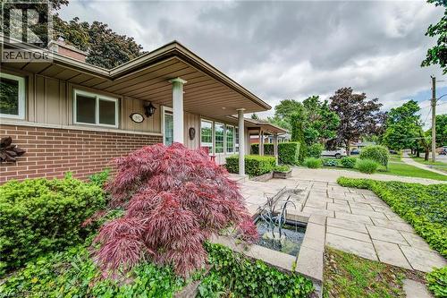 Brick and siding exterior with a covered entry, established landscaping, and a paver stone walkway - 192 Warren Road, Kitchener, ON 