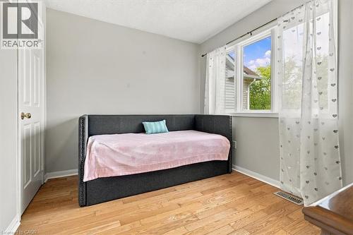 Wood-finish flooring with a multi-pane window and a classic paneled door - 5180 Oakley Drive, Burlington, ON 
