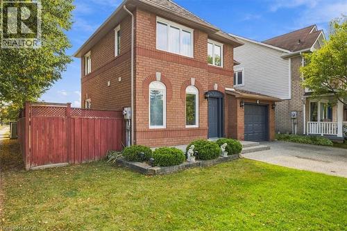 Brick exterior with a peaked roof, arched windows, and an attached garage - 5180 Oakley Drive, Burlington, ON 