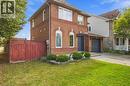 Brick exterior with a peaked roof, arched windows, and an attached garage - 5180 Oakley Drive, Burlington, ON 