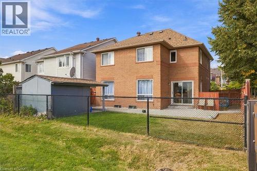 Brick exterior with multiple windows, a rear patio, and a built-in shed - 5180 Oakley Drive, Burlington, ON 