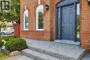 Brick facade featuring arched window details, a paneled entry door with sidelights, and exterior lighting fixtures - 5180 Oakley Drive, Burlington, ON 
