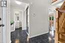 Tiled entryway with mirrored closet doors, a light wood staircase, and a visible powder room featuring a single vanity - 5180 Oakley Drive, Burlington, ON 