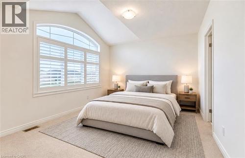 Arched window with plantation shutters, vaulted ceiling, recessed lighting, wall-to-wall carpeting, and a built-in door frame - 52 Pointer Street, Cambridge, ON 