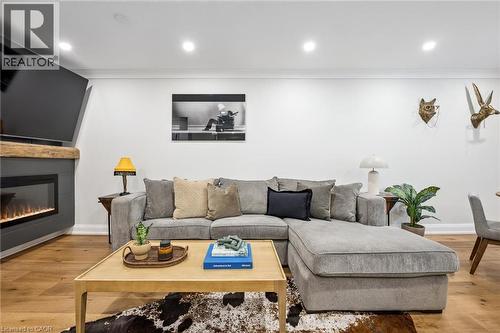 Hardwood flooring, crown molding, recessed lighting, and a modern fireplace with a wooden mantel - 1261 Stephenson Drive, Burlington, ON 