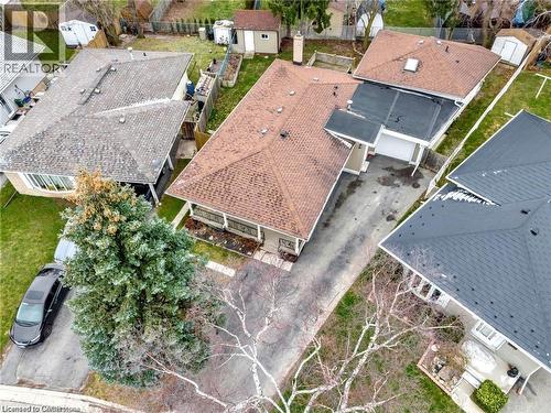 Paved driveway with attached garage, mature front yard tree, and gabled roofline - 93 Robertson Crescent, Kitchener, ON 