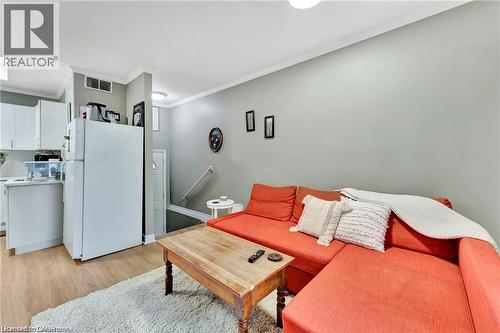 Open-concept living area with wood-finish flooring, white cabinetry, and recessed lighting - 93 Robertson Crescent, Kitchener, ON 