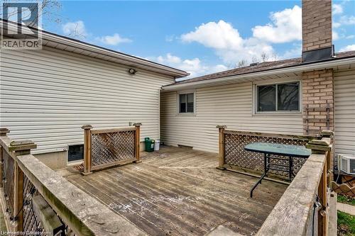 Expansive outdoor deck with wood railings, lattice accents, and brick chimney detail - 93 Robertson Crescent, Kitchener, ON 