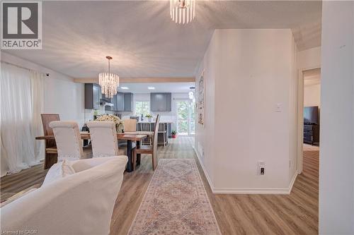 Wood-finish flooring throughout, modern overhead lighting, white walls, and white baseboards - 317 Christopher Drive, Cambridge, ON 