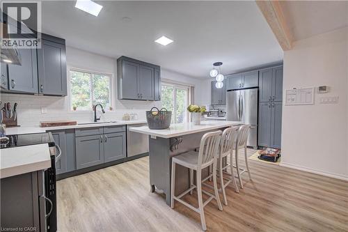 Kitchen featuring gray shaker-style cabinetry, white countertops, subway tile backsplash, stainless steel appliances, and wood-finish flooring - 317 Christopher Drive, Cambridge, ON 