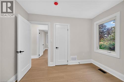 Light wood-finish flooring with white trim - 50 West 4Th Street, Hamilton, ON 
