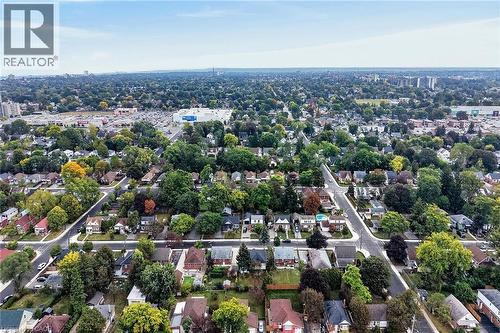 Aerial perspective showcasing a residential neighborhood with diverse architectural styles, mature trees, and a clear sky backdrop - 50 West 4Th Street, Hamilton, ON 