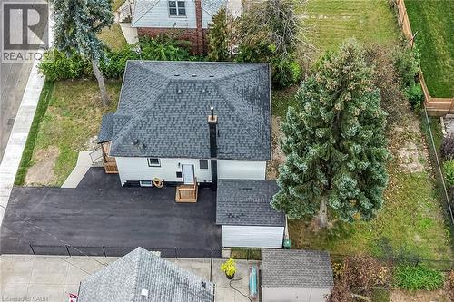 Asphalt shingle roof, white siding, black driveway, wood decks, and an attached garage - 50 West 4Th Street, Hamilton, ON 