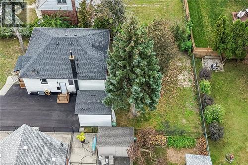 Expansive backyard featuring a manicured lawn, established landscaping, privacy fencing, and a fire pit area - 50 West 4Th Street, Hamilton, ON 