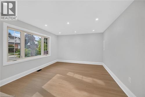 Bright and airy room featuring gleaming wood-finish flooring, crisp white walls, and recessed ceiling lighting - 50 West 4Th Street, Hamilton, ON 