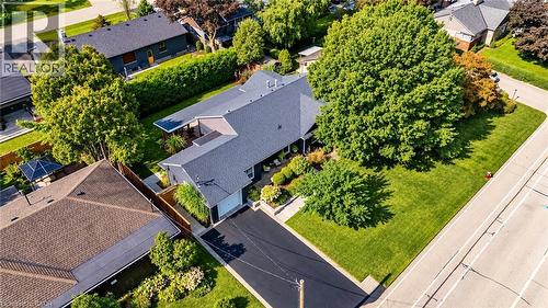 Pitched roofline residence with an attached garage, featuring a paved driveway, mature trees, and established landscaping - 896 Eagle Drive, Burlington, ON 