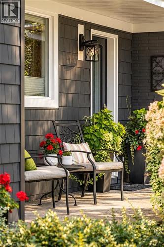 Exterior featuring dark gray shingle siding, white trim accents, and a black outdoor wall lantern - 896 Eagle Drive, Burlington, ON 