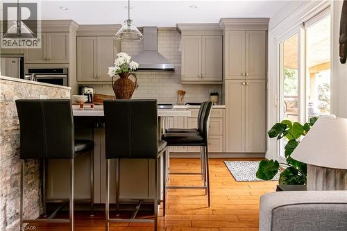 Contemporary kitchen and dining area featuring custom cabinetry with soft-close doors, quartz countertops, and a subway tile backsplash - 896 Eagle Drive, Burlington, ON 