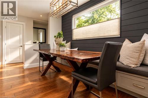 Wood-finish flooring, built-in bench seating with storage drawers, horizontal wood paneling, recessed lighting, and a decorative ceiling fixture - 896 Eagle Drive, Burlington, ON 