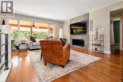 Hardwood flooring, recessed lighting, and a modern fireplace with a stone-finish accent wall - 896 Eagle Drive, Burlington, ON 