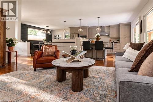 Open-concept living space featuring wood-finish flooring, recessed lighting, and a kitchen with pendant lights and a stainless steel range hood - 896 Eagle Drive, Burlington, ON 