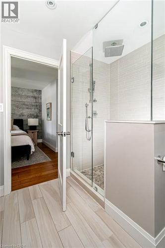 Walk-in shower featuring a glass enclosure, rain shower head, and light-toned subway tile surround - 896 Eagle Drive, Burlington, ON 