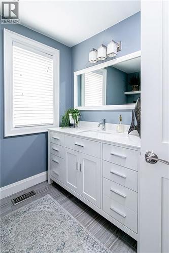White shaker-style vanity with ample storage and a light-toned countertop - 896 Eagle Drive, Burlington, ON 