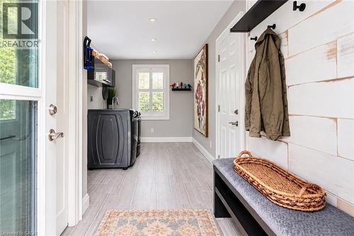 Dedicated laundry area with light wood-finish flooring, recessed lighting, and a window - 896 Eagle Drive, Burlington, ON 
