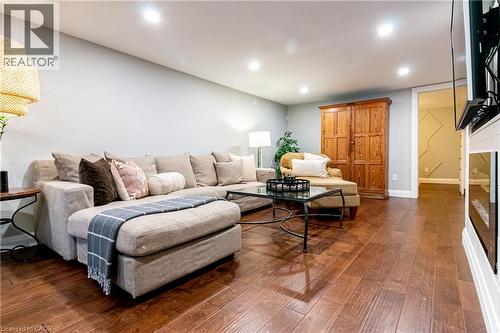 Recessed lighting illuminating wood-finish flooring, a built-in electric fireplace, and a light gray wall finish - 896 Eagle Drive, Burlington, ON 