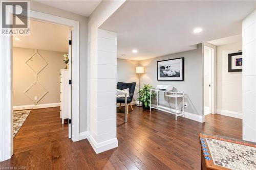 Spacious open-concept layout featuring warm wood-finish flooring throughout, recessed ceiling lighting, and architectural columns defining distinct living zones - 896 Eagle Drive, Burlington, ON 