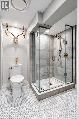 Glass-enclosed shower with gray tiled walls and bronze fixtures - 896 Eagle Drive, Burlington, ON 