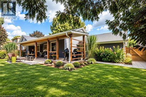 Expansive backyard with a covered patio, concrete paving, and a manicured lawn - 896 Eagle Drive, Burlington, ON 