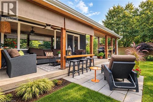 Expansive outdoor patio with wood-finish ceiling, exposed wood beams, and a ceiling fan - 896 Eagle Drive, Burlington, ON 